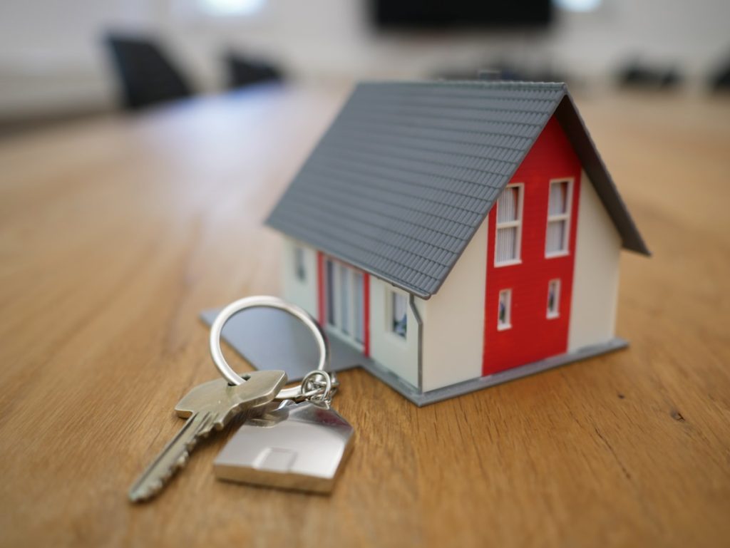 House keys and financial documents comparing annuity vs real estate passive income