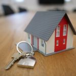 House keys and financial documents comparing annuity vs real estate passive income